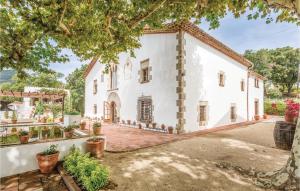an exterior view of a white house with a tree at Beautiful Home In Arenys De Munt With 6 Bedrooms, Private Swimming Pool And Outdoor Swimming Pool in Arenys de Munt