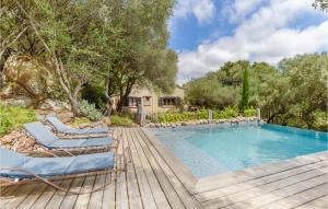 a swimming pool with chairs and a wooden deck at Beautiful Home In Sartene With Wifi in Sartène