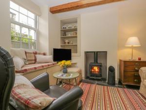 a living room with a couch and a fireplace at Hawthorn Cottage in Ulverston
