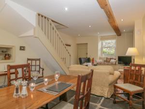 a living room with a table and a couch at Hawthorn Cottage in Ulverston
