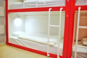 a red bunk bed with a bed in a room at London Mini-hotel in Yekaterinburg