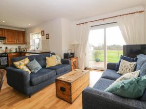 ein Wohnzimmer mit zwei Sofas und einem Tisch in der Unterkunft Broom Cottage in Sidmouth