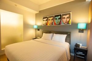 a hotel room with a bed and a poster of actors at idoop Hotel Lombok in Mataram