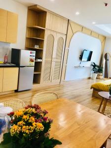 a kitchen and living room with a wooden table with flowers at TMS RUSTIC Beach in Quy Nhon