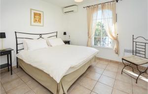 Un dormitorio con una gran cama blanca y una ventana. en 2 Bedroom Cozy Home In Aigues-Mortes, en Aigues-Mortes