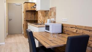 una cocina con mesa de madera y microondas. en Gästehaus - Boardinghouse Magnetsried en Seeshaupt
