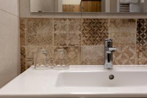 ein Waschbecken mit zwei Gläsern drauf in der Unterkunft Gästehaus - Boardinghouse Magnetsried in Seeshaupt + 2 Fotos