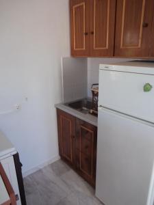 a kitchen with a white refrigerator and a sink at renesis studios in Lithakia