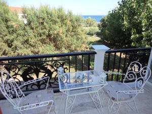 a group of chairs and a table on a balcony at renesis studios in Lithakia