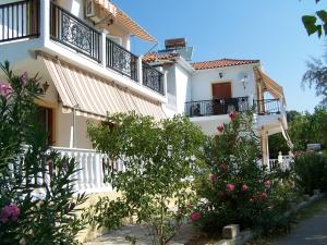 a building with balconies and flowers in front of it at renesis studios in Lithakia