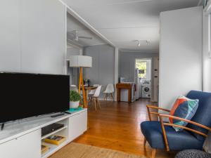 a living room with a large flat screen tv at Sirocco Cottage - pet-friendly Huskisson home in Huskisson