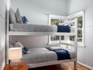 two bunk beds in a room with a table at Sirocco Cottage - pet-friendly Huskisson home in Huskisson