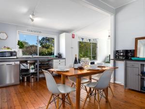 a kitchen with a wooden table and chairs at Sirocco Cottage - pet-friendly Huskisson home in Huskisson