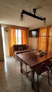 a living room with a wooden table and a couch at La Rosadita - Casa de Montaña in Achiras