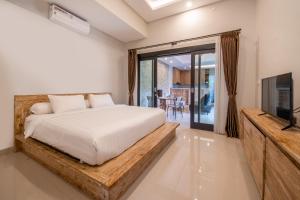 Un dormitorio con una cama y un televisor de pantalla plana. en Viros Luxury Villa 2BR Private Pool, en Jimbaran 8 fotos más