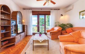 a living room with orange furniture and a television at Gorgeous Apartment In Selce With Wifi in Selce