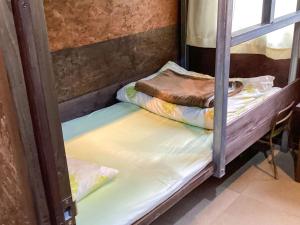 two bunk beds in a room with a window at Sesoko Island Guest House Kafuu Village in Motobu