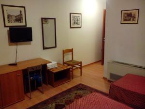 - un salon avec une télévision, un bureau et une chaise dans l'établissement Albergo Alla Speranza, à Castelfranco Veneto