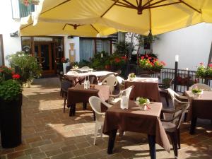 カステルフランコ・ヴェーネトにあるAlbergo Alla Speranzaの黄色い傘を敷いたテーブルと椅子が備わるレストラン