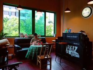 a woman sitting at a table in a living room at Foshan Cuba Youth Hostel in Foshan