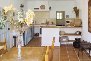 a kitchen with a table with a vase of flowers on it at La Casita in Periana