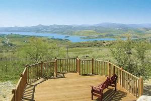 a wooden walkway with a bench and a lake at La Casita in Periana