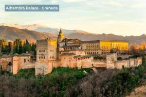 a large castle on a hill with mountains in the background at La Casita in Periana