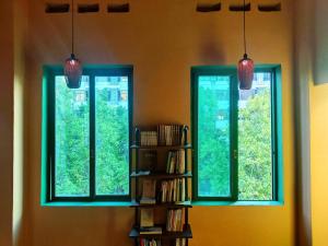 2 ventanas en una habitación con estantería en Foshan Cuba Youth Hostel, en Foshan