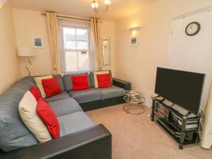 a living room with a couch and a tv at Gone Sailing in Weymouth