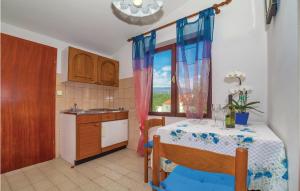 a small kitchen with a table and a window at Nice Apartment In Crikvenica With House Sea View in Crikvenica