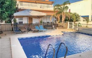 a swimming pool with blue chairs and an umbrella at 6 Bedroom Beautiful Home In La Azohia in La Azohía