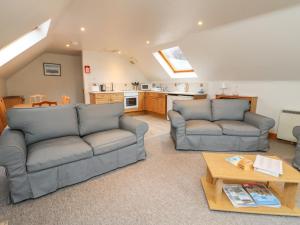 a living room with two couches and a table at Wallace in Pitlochry