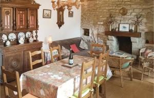 a living room with a table and a fireplace at Nice Home In Plomeur With 5 Bedrooms in Kermathéano