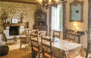 a dining room with a table and a fireplace at Nice Home In Plomeur With 5 Bedrooms in Kermathéano
