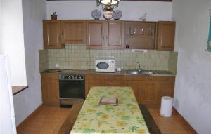 cocina con armarios de madera y mesa con microondas en Holiday Home Kermathéano, en Kermathéano 10 fotos más