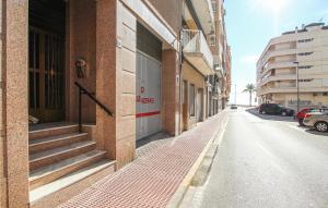 pusta ulica obok ceglanego budynku w obiekcie 2 Bedroom Cozy Apartment In Santa Pola w mieście Santa Pola