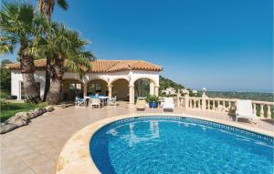 a villa with a swimming pool in front of a house at La Sella in Pedreguer