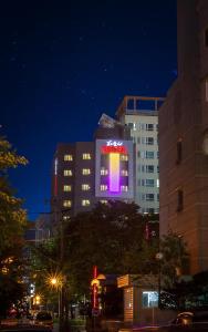 un bâtiment avec un panneau violet sur lui la nuit dans l'établissement Harmony Hotel, à Séoul