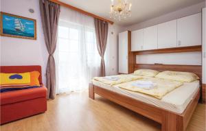 ein Schlafzimmer mit einem Bett und einem Stuhl und einem Fenster in der Unterkunft Awesome Apartment In Crikvenica in Crikvenica