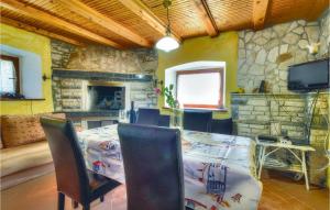 a dining room with a table and a stone wall at 2 Bedroom Stunning Home In Kastel in Kaštel