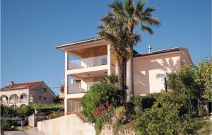 a building with a palm tree in front of a building at 4 Bedroom Lovely Home In Supetarska Draga in Supetarska Draga