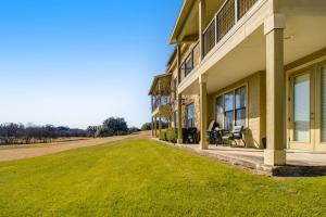 a house with a green lawn next to a building at Golfer's Paradise in New Braunfels