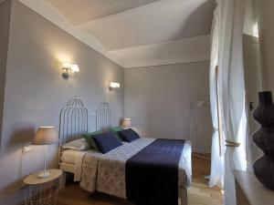 a bedroom with a bed with blue and green pillows at Between sky and sea in an exclusive village full of charm with a private terrace in Campiglia Marittima