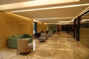 a lobby with a green couch and chairs at The Kings Park Grand-Near US Consulate in Chennai