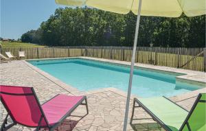 two chairs and an umbrella next to a swimming pool at Awesome Home In Campsegret in Campsegret