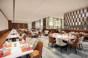 a dining room with tables and chairs and a restaurant at La Quinta by Wyndham Weifang South in Weifang