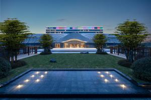 a night view of a building with a swimming pool at La Quinta by Wyndham Weifang South in Weifang