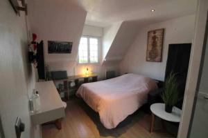 a bedroom with a bed and a desk and a window at Cosy Solidor Beach View in Saint Malo