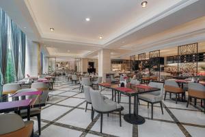 a restaurant with tables and chairs in a room at Park Plaza Changzhou, A member of Radisson Hotel&Resorts in Changzhou