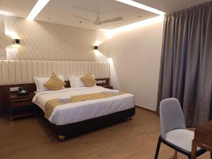 Habitación de hotel con cama y silla en The Kings Park Grand-Near US Consulate en Chennai